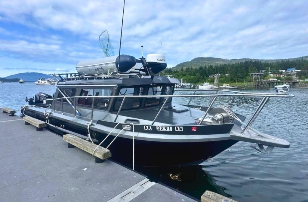 The KingFisher offshore cruiser docked at a Juneau harbor pier, radar dome and fishing gear visible.